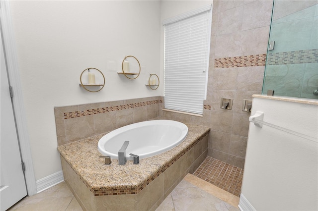 bathroom featuring a garden tub, tile patterned flooring, baseboards, and a tile shower