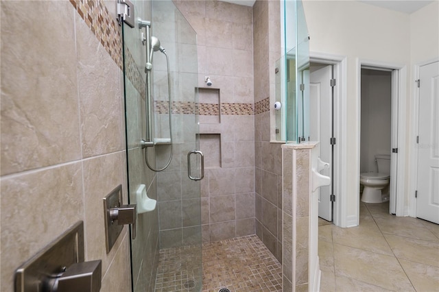 full bath featuring tile patterned flooring, a shower stall, and toilet