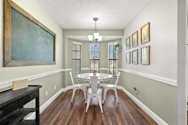 dining room featuring dark hardwood / wood-style flooring, a textured ceiling, and an inviting chandelier