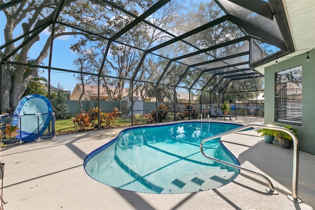 view of swimming pool featuring a patio area and glass enclosure