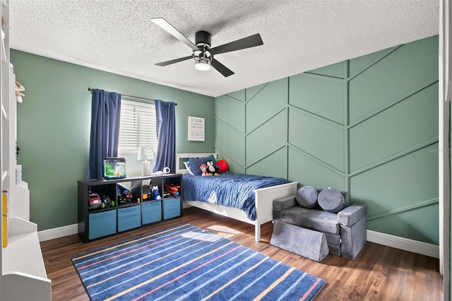 bedroom with ceiling fan, dark hardwood / wood-style flooring, and a textured ceiling