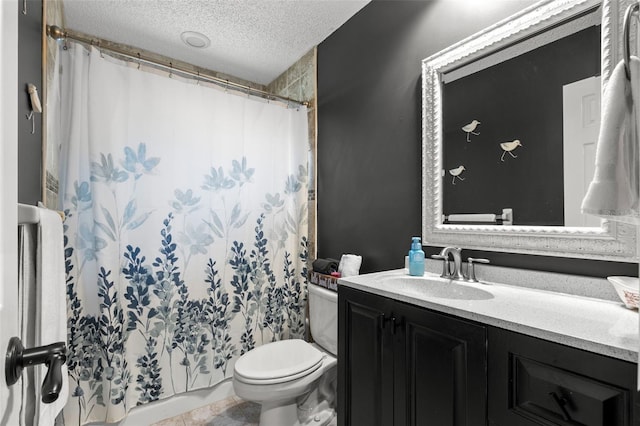 bathroom featuring vanity, tile patterned floors, a textured ceiling, and toilet