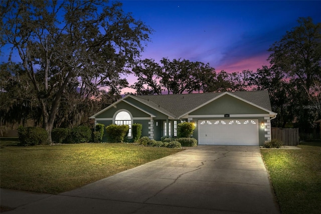 ranch-style home with a yard and a garage