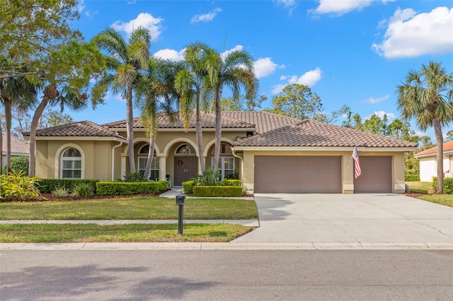 mediterranean / spanish home with a garage and a front lawn