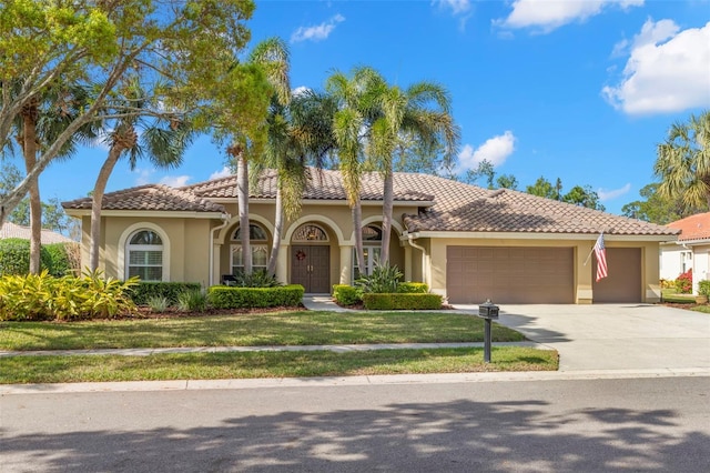 mediterranean / spanish-style house with a garage and a front lawn