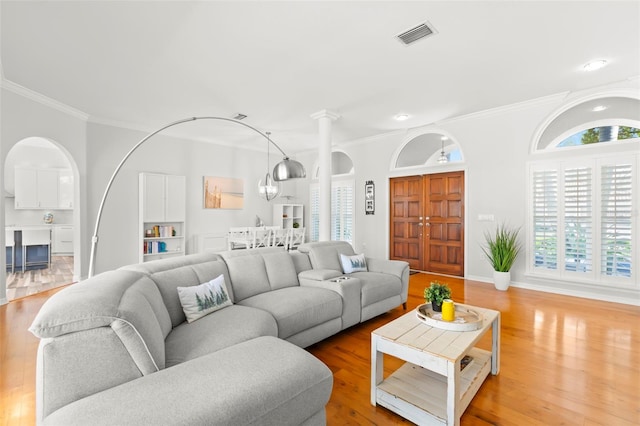 living room with ornamental molding and light wood-type flooring