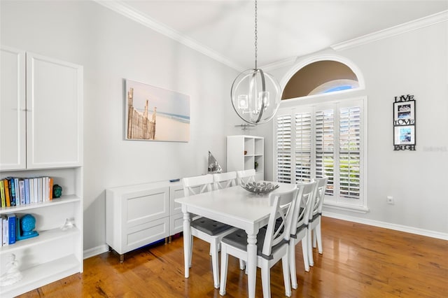 dining area featuring dark wood-type flooring, ornamental molding, and a notable chandelier