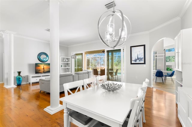 dining space with an inviting chandelier, a wealth of natural light, decorative columns, and light wood-type flooring