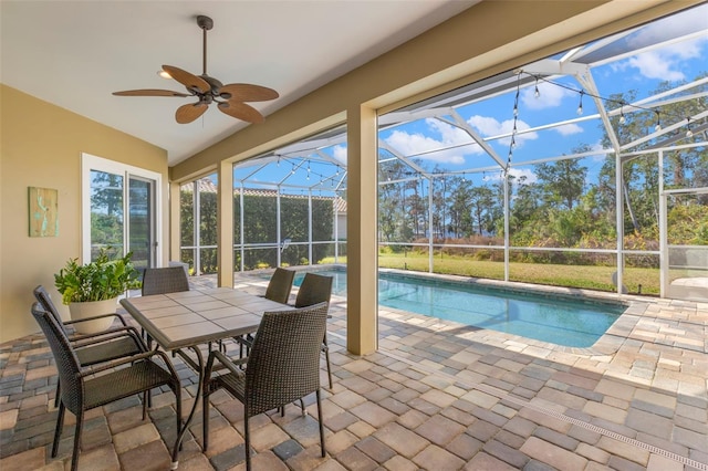 view of swimming pool featuring a patio area, ceiling fan, and glass enclosure