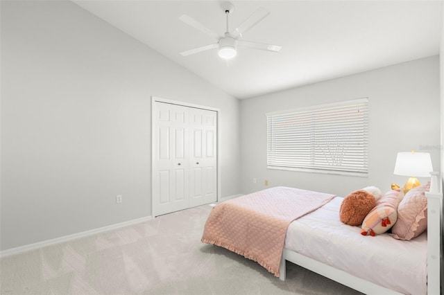 bedroom with light carpet, vaulted ceiling, a closet, and ceiling fan