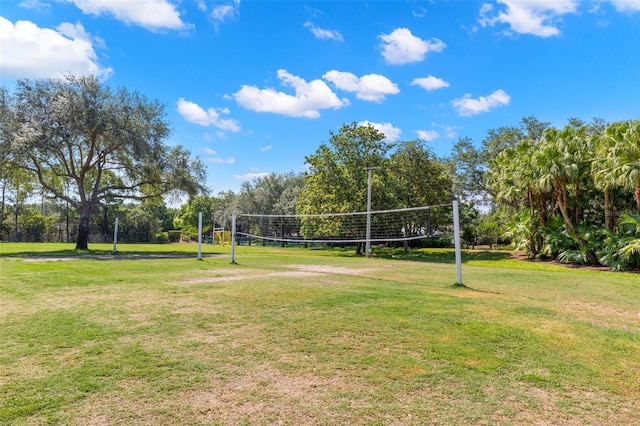 surrounding community with volleyball court and a lawn