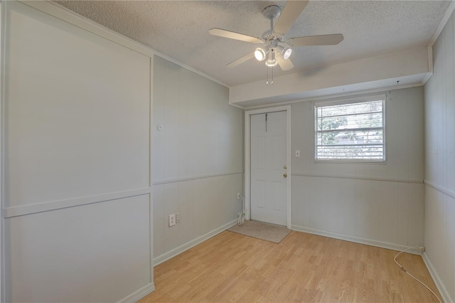 foyer with ceiling fan, crown molding, light hardwood / wood-style floors, and a textured ceiling