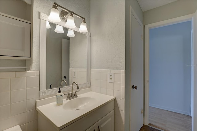 bathroom featuring vanity and tile walls