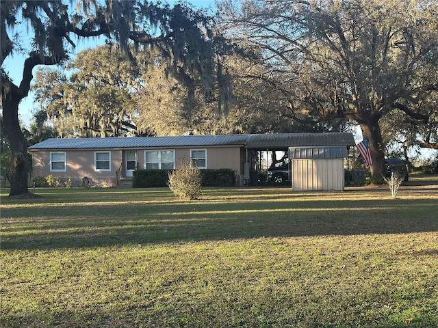 view of front of house with a carport and a front lawn