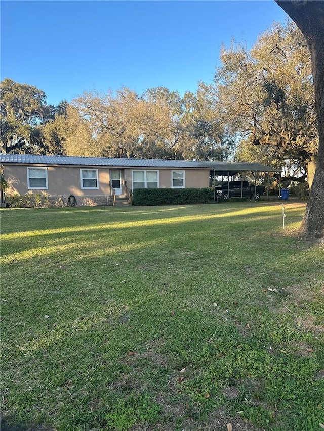 view of front of home with a carport and a front yard