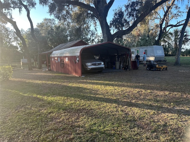 view of outbuilding featuring a carport and a yard