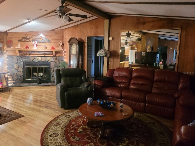 living room with a fireplace, wooden walls, lofted ceiling with beams, wood-type flooring, and ceiling fan