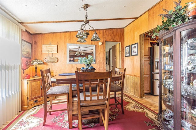 dining area with wooden walls and a textured ceiling