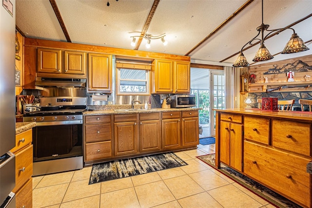 kitchen featuring sink, light tile patterned floors, decorative light fixtures, and appliances with stainless steel finishes