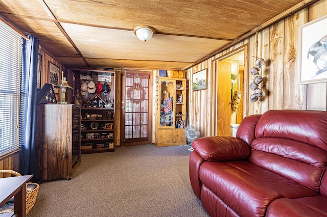 sitting room featuring carpet flooring, wood ceiling, and wooden walls