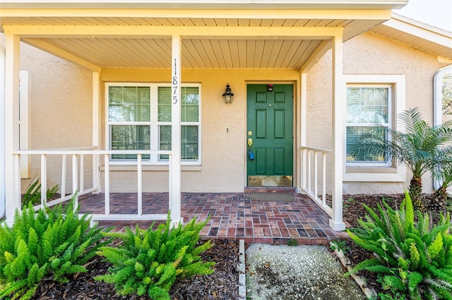 view of exterior entry with a porch