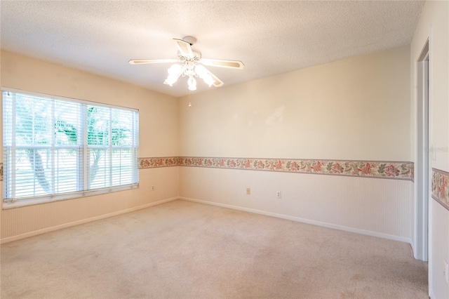 carpeted empty room with a textured ceiling and ceiling fan