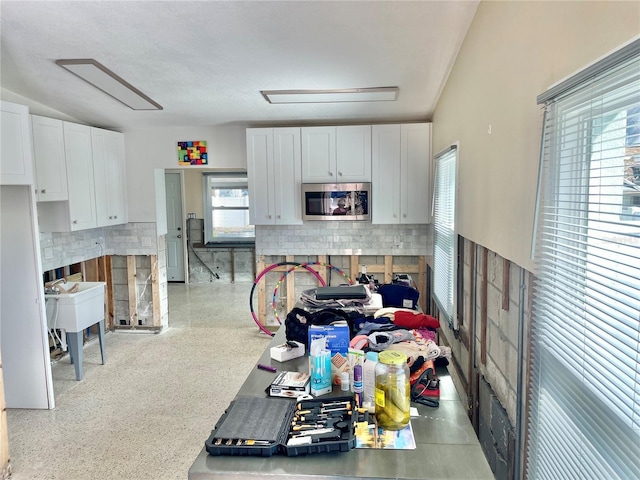 kitchen with backsplash, sink, and white cabinets