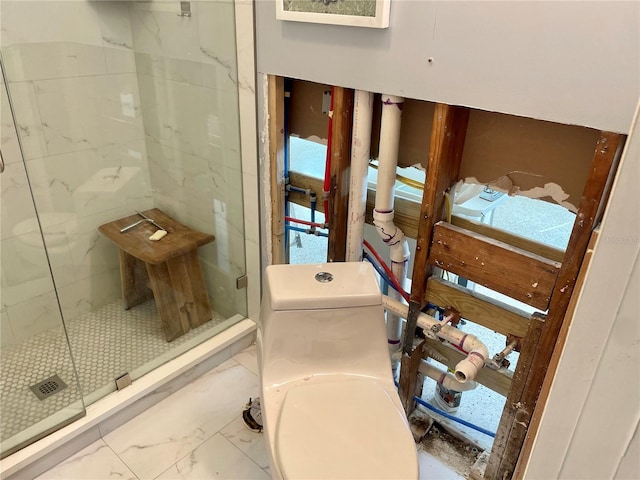 bathroom with toilet and a shower with door