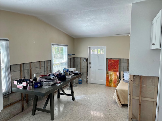 office area with ceiling fan, vaulted ceiling, and a textured ceiling