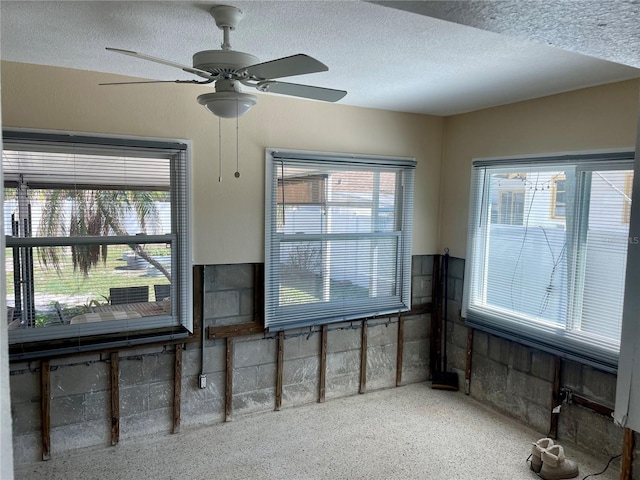 interior space with ceiling fan and a textured ceiling