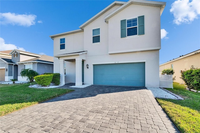 view of front of house with a garage, a front yard, decorative driveway, and stucco siding