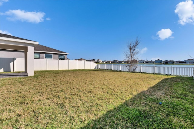 view of yard with a water view and fence