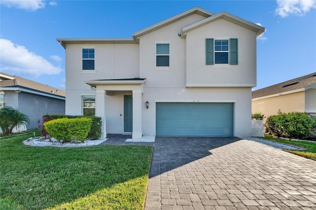 view of front of property with an attached garage, a front yard, decorative driveway, and stucco siding