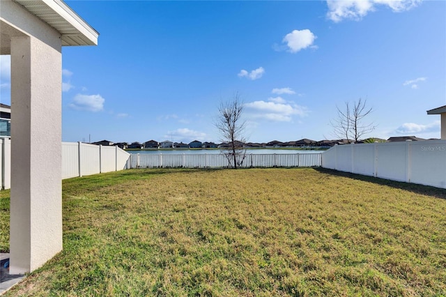 view of yard featuring a water view and a fenced backyard