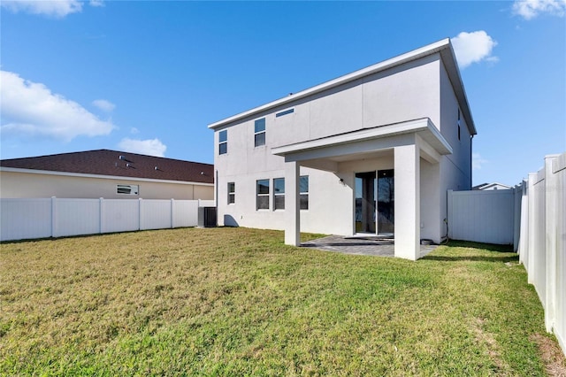 back of property featuring a lawn, a patio area, a fenced backyard, and stucco siding