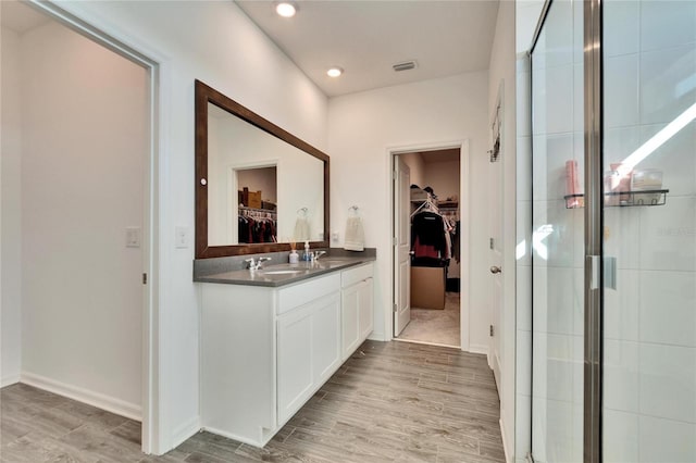 bathroom featuring a stall shower, visible vents, vanity, and wood finished floors