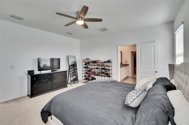 bedroom with a ceiling fan, light colored carpet, and visible vents