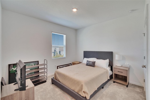 bedroom featuring baseboards and light colored carpet