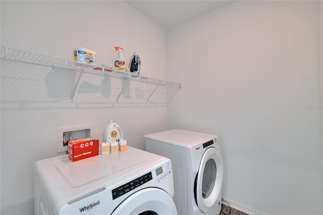 laundry area with laundry area, washing machine and dryer, and baseboards