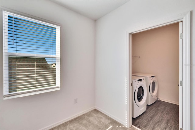 laundry area featuring baseboards, laundry area, wood finished floors, and washer and dryer