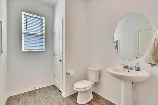 bathroom featuring wood finished floors, toilet, and baseboards