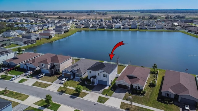 drone / aerial view featuring a residential view and a water view