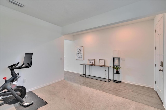 workout room featuring baseboards, visible vents, carpet flooring, and wood finished floors