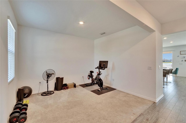 workout room with light wood-type flooring, visible vents, baseboards, and recessed lighting