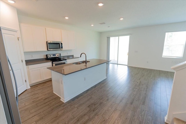 11827 Cara Field Ave, Riverview, FL 33579 - kitchen with stainless steel appliances, a sink, dark countertops, wood finished floors, and recessed lighting