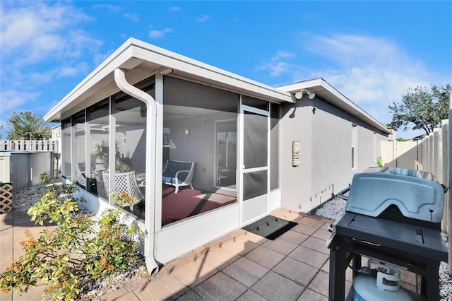 view of side of property with a sunroom and a patio