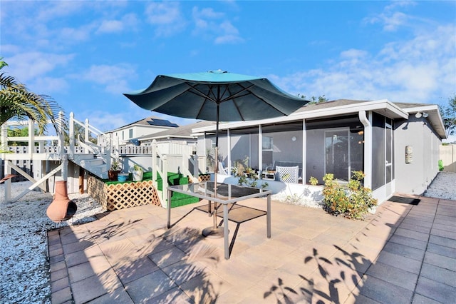 view of patio featuring a sunroom