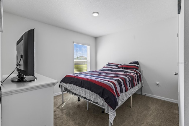 bedroom featuring a textured ceiling, carpet flooring, and baseboards