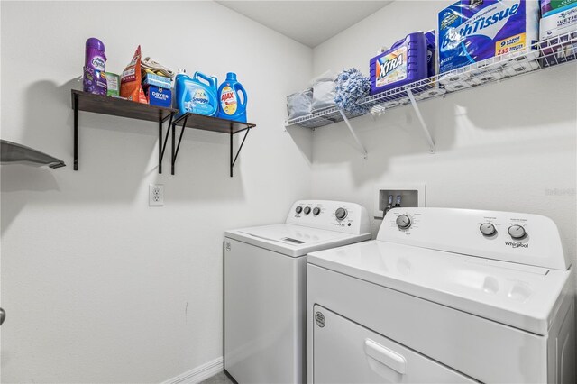 clothes washing area with laundry area, washing machine and dryer, and baseboards