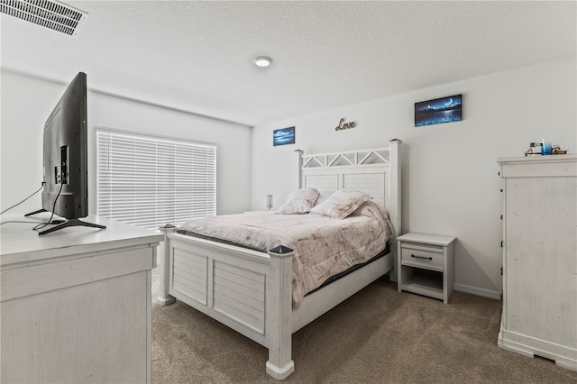 bedroom with a textured ceiling, dark colored carpet, visible vents, and baseboards